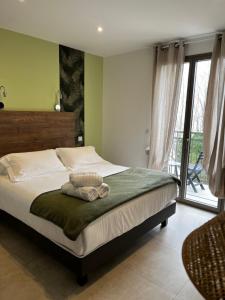 a bedroom with a bed with a green wall at Hôtel du Golfe Pinarello in Pinarellu