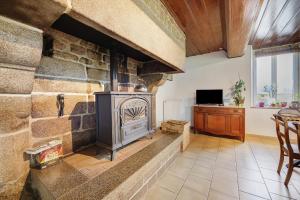 a stone fireplace in a living room with a tv at La Bourgerie in Saint-Aubin-des-Bois