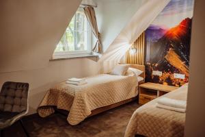 ein Schlafzimmer mit zwei Betten und einem Fenster in der Unterkunft Lekkoduch in Świeradów-Zdrój