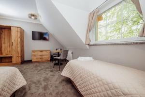 ein Schlafzimmer mit zwei Betten, einem Fenster und einem Tisch in der Unterkunft Lekkoduch in Świeradów-Zdrój