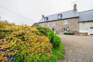 a brick house with flowers in front of it at La Bourgerie in Saint-Aubin-des-Bois