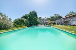 a large swimming pool with blue water at Domaine De Bellerose in Cadeillan