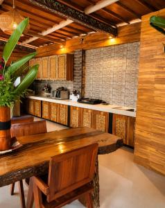 a large kitchen with a wooden table and a counter at Namali Private Villa in Gili Trawangan