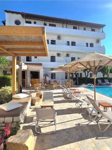 Ein Hotel mit Liegestühlen und Sonnenschirmen neben einem Pool in der Unterkunft Archontiko Hotel in Ammoudara