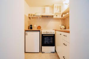 eine Küche mit einem weißen Kühlschrank und einem Geschirrspüler in der Unterkunft Mountain Mini Suite in Áyioi Dhéka + 14 Fotos