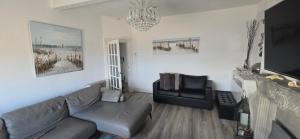 a living room with a couch and a chair at Stunning Harbour View Beachfront Apartment Parking in Rhos-on-Sea