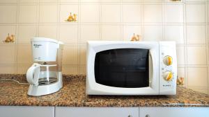 a microwave sitting on a counter next to a coffee maker at Villa Mª José in Benicarló