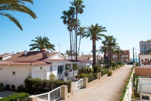 a house on a street with palm trees at Villa Mª José in Benicarló