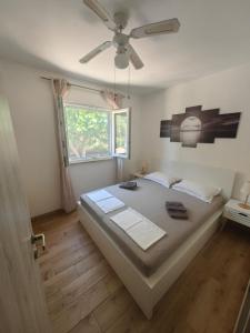 a bedroom with a large bed with a ceiling fan at Apartment Miljenko Tomić in Splitska