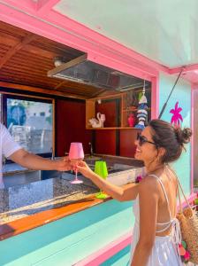 a woman is getting a drink from a bartender at Mojo Resort in Eforie Sud +99 photos