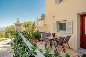 eine Terrasse mit Tisch und Stühlen und ein Balkon in der Unterkunft Mountain Mini Suite in Áyioi Dhéka