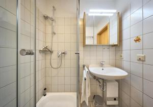 a bathroom with a shower and a sink and a tub at Elbe I, Ferienwohnung 29 in Cuxhaven