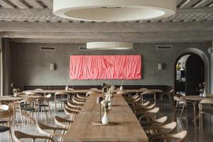 a room with tables and chairs and a red painting on the wall at Hotel Linde 4 S in Maria Wörth