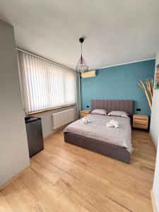 a bedroom with a bed and a blue wall at Семейна къща “Вълчеви” in Kiten