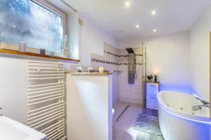 a bathroom with a tub and a sink at Ferienresidenz Villa Kunterbunt in Warstein +41 photos