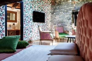 a bedroom with two chairs and a bed and a stone wall at Aurum Collection - Como Suites in Como +62 photos