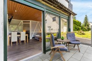 a patio with glass doors and a table and chairs at Ferienresidenz Villa Kunterbunt in Warstein