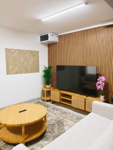 a living room with a large television and a table at Sunshine Sally in St. Helena Bay