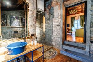 a bathroom with a blue tub on a wooden table at Aurum Collection - Como Suites in Como