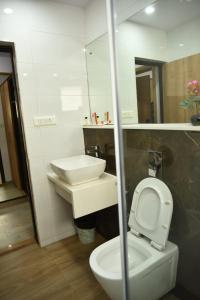 a bathroom with a white toilet and a sink at Aditya Homes Gachibowli in Hyderabad +7 photos