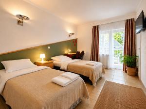 a hotel room with two beds and a television at Airport Messe Villa Casa in Düsseldorf