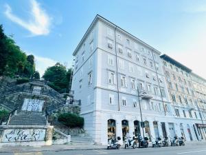 a white building with motorcycles parked in front of it at James Joyce Luxury Apartment in Trieste