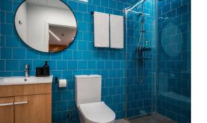 a blue tiled bathroom with a toilet and a mirror at SociaLodge - Piornais in Funchal +27 photos