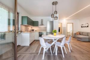 a kitchen and dining room with a white table and chairs at Maison Bovet Appartements in Arvier