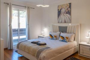 a bedroom with a bed with a painting on the wall at Apartamento Luar in Ribeira Brava