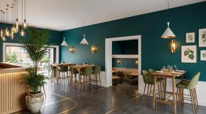 a restaurant with green walls and tables and chairs at ROMSEN Nambucca Valley in Macksville