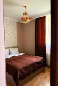 a bedroom with a bed and a chandelier at Little house Kazbegi in Kazbegi