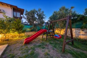 a playground with a red slide in a yard at VILLA ALKIM in Kaş