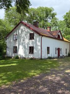 an old white house with a red roof at Flishult gård in Vetlanda