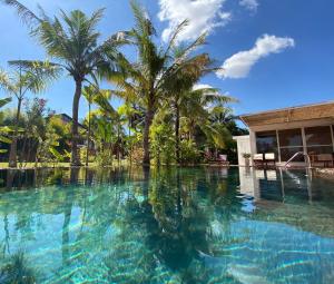 a swimming pool with palm trees and a building at Angkor Private villa Siem Reap in Siem Reap