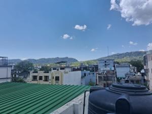 a view of a city with a green roof at Blue Breeze in Haridwār
