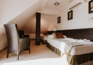 a hotel room with a bed and a chair at Hotel Bonaparte in Košice