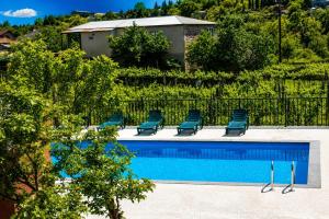 a swimming pool with chairs and a poolvisorvisorvisor at Hotel Chiatureli in Chiatʼura
