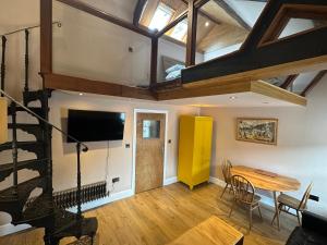 a living room with a wooden table and a loft at Urban Perch in Penrith
