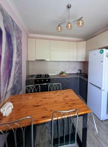 a kitchen with a wooden table and a white refrigerator at Little house Kazbegi in Kazbegi