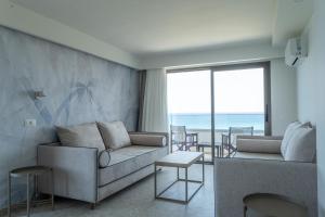 a living room with a couch and a view of the ocean at Iberostar Waves Creta Panorama & Mare in Panormos Rethymno +93 photos