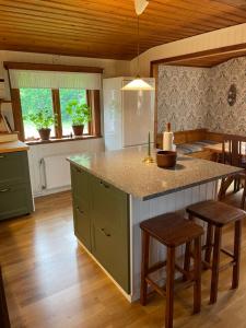 a kitchen with a large island with stools in it at Stugan i Gesunda in Sollerön