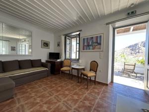 a living room with a couch and a table and chairs at KK Houses in Hydra