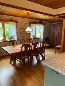 a kitchen and dining room with a wooden table and chairs at Stugan i Gesunda in Sollerön +14 photos