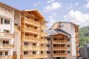 a building with wooden balconies on the side of it at Résidence Arya - Living Stone in Vars