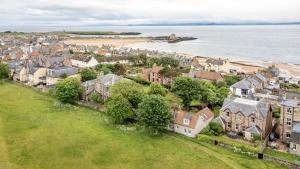 an aerial view of a town with houses and the ocean at Stable Cottage - Elie in Elie