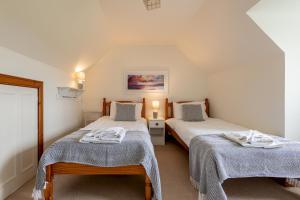 two beds in a small room with two twin beds at Stable Cottage - Elie in Elie