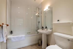 a bathroom with a shower and a sink and a toilet at Stable Cottage - Elie in Elie +19 photos