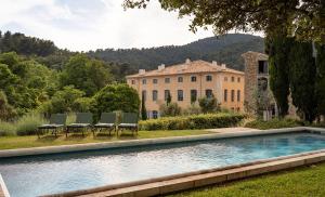 a house with a swimming pool in front of a building at Château du Grand Pré in Vitrolles-en-Luberon