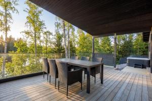 a wooden deck with a table and chairs on it at Villa Karina - Beachfront with Jacuzzi in Porvoo