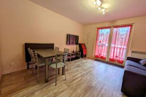 a living room with a table and chairs and a couch at Studio 5 personnes au revard in Les Déserts